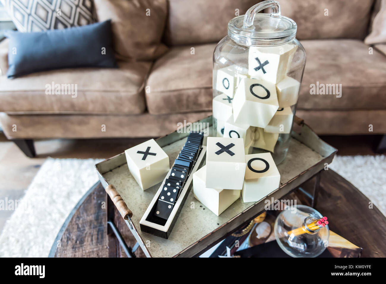 Sala gioco vassoio stand con x e o, domino, sul tavolino da caffè in modello di staging di casa o appartamento in pelle marrone lettino Foto Stock