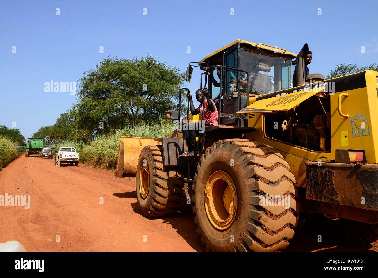 Etiopia, Gambela, Abobo, il governo dare grandi terreni a buon mercato per i leasing per gli investitori nazionali e stranieri, dopo la deforestazione gli investitori coltivare grande Fattoria Terre di coltura alimentare per l'esportazione, le popolazioni locali sono spesso risolte sotto programmi villagization, mietitrebbia John Deere Harvester di Arabia Star lo sviluppo agricolo PLC è spostato su strada stretta per il raccolto di riso , Arabia Star posseduto dal miliardario Saudi-Ethiopian Sheikh Mohamed al-Amoudi ha una fattoria di riso di circa 10.000 ettari lungo il fiume Alwero / AETHIOPIEN, Gambela, Abobo, die aethiopische Regierung verpachtet grosse Landflaech Foto Stock