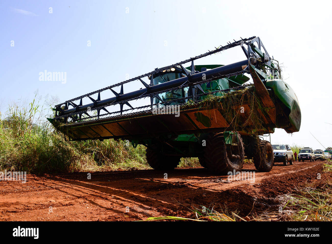 Etiopia, Gambela, Abobo, il governo dare grandi terreni a buon mercato per i leasing per gli investitori nazionali e stranieri, dopo la deforestazione gli investitori coltivare grande Fattoria Terre di coltura alimentare per l'esportazione, le popolazioni locali sono spesso risolte sotto programmi villagization, mietitrebbia John Deere Harvester di Arabia Star lo sviluppo agricolo PLC è spostato su strada stretta per il raccolto di riso , Arabia Star posseduto dal miliardario Saudi-Ethiopian Sheikh Mohamed al-Amoudi ha una fattoria di riso di circa 10.000 ettari lungo il fiume Alwero / AETHIOPIEN, Gambela, Abobo, die aethiopische Regierung verpachtet grosse Landflaech Foto Stock