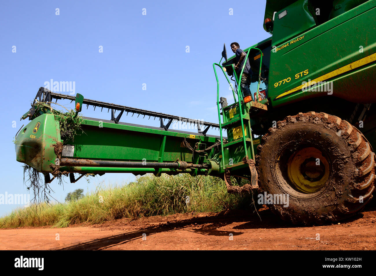 Etiopia, Gambela, Abobo, il governo dare grandi terreni a buon mercato per i leasing per gli investitori nazionali e stranieri, dopo la deforestazione gli investitori coltivare grande Fattoria Terre di coltura alimentare per l'esportazione, le popolazioni locali sono spesso risolte sotto programmi villagization, mietitrebbia John Deere Harvester di Arabia Star lo sviluppo agricolo PLC è spostato su strada stretta per il raccolto di riso , Arabia Star posseduto dal miliardario Saudi-Ethiopian Sheikh Mohamed al-Amoudi ha una fattoria di riso di circa 10.000 ettari lungo il fiume Alwero / AETHIOPIEN, Gambela, Abobo, die aethiopische Regierung verpachtet grosse Landflaech Foto Stock