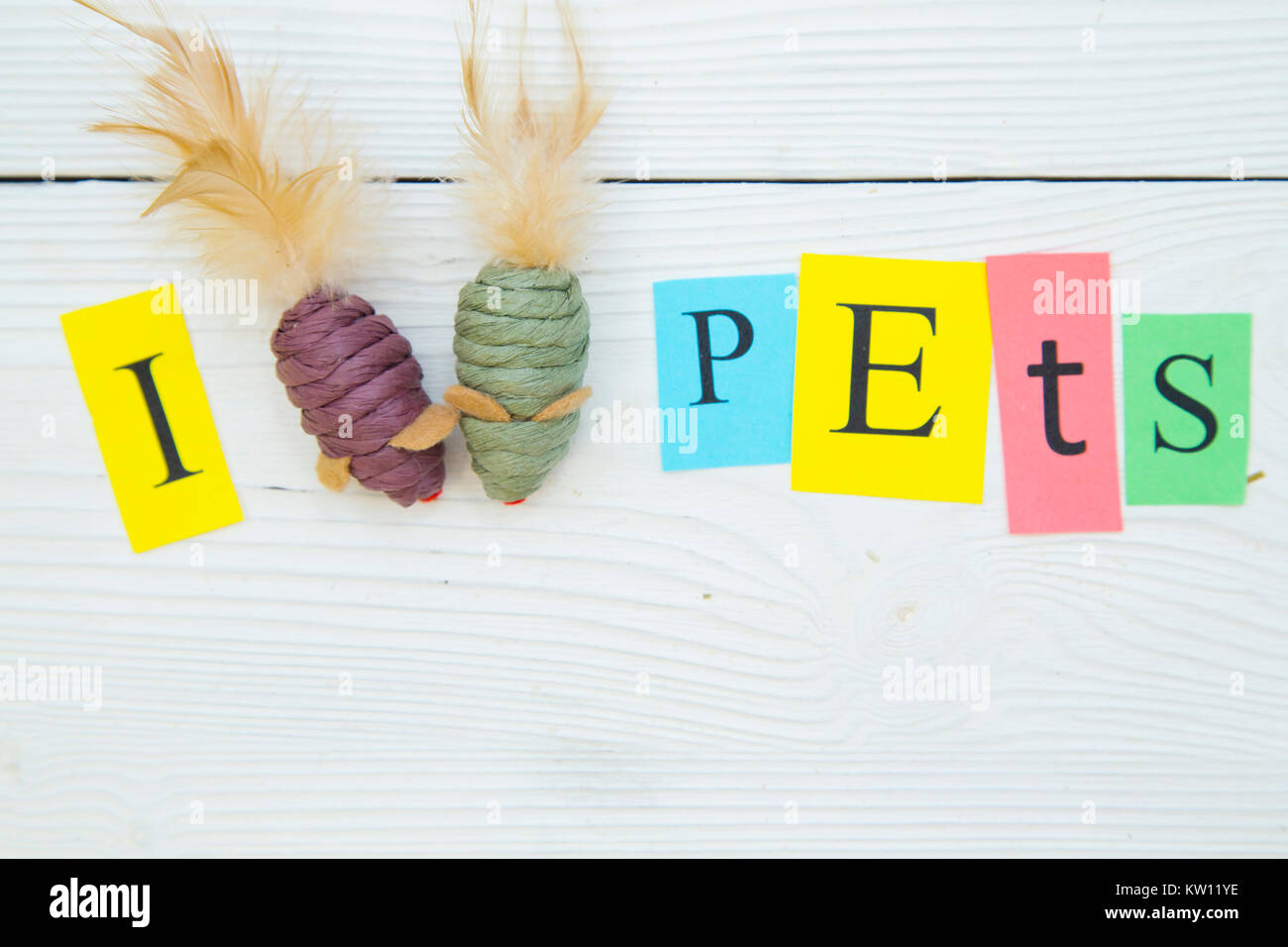 Io amo gli animali domestici iscrizione fatta di stampate lettere e due topi giocattolo. Un bianco sullo sfondo di legno. Lo spazio per il tuo testo o immagine. Foto Stock