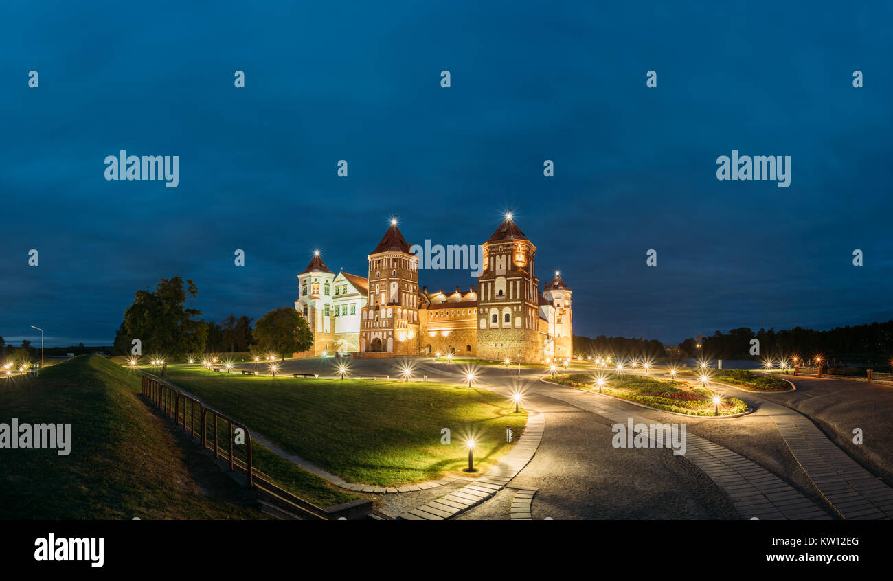 Mir, Bielorussia. Complesso del Castello di Mir in serata luci di illuminazione. Famoso punto di riferimento, antico monumento gotico del feudalesimo sotto la notte blu cielo. UNESCO Foto Stock