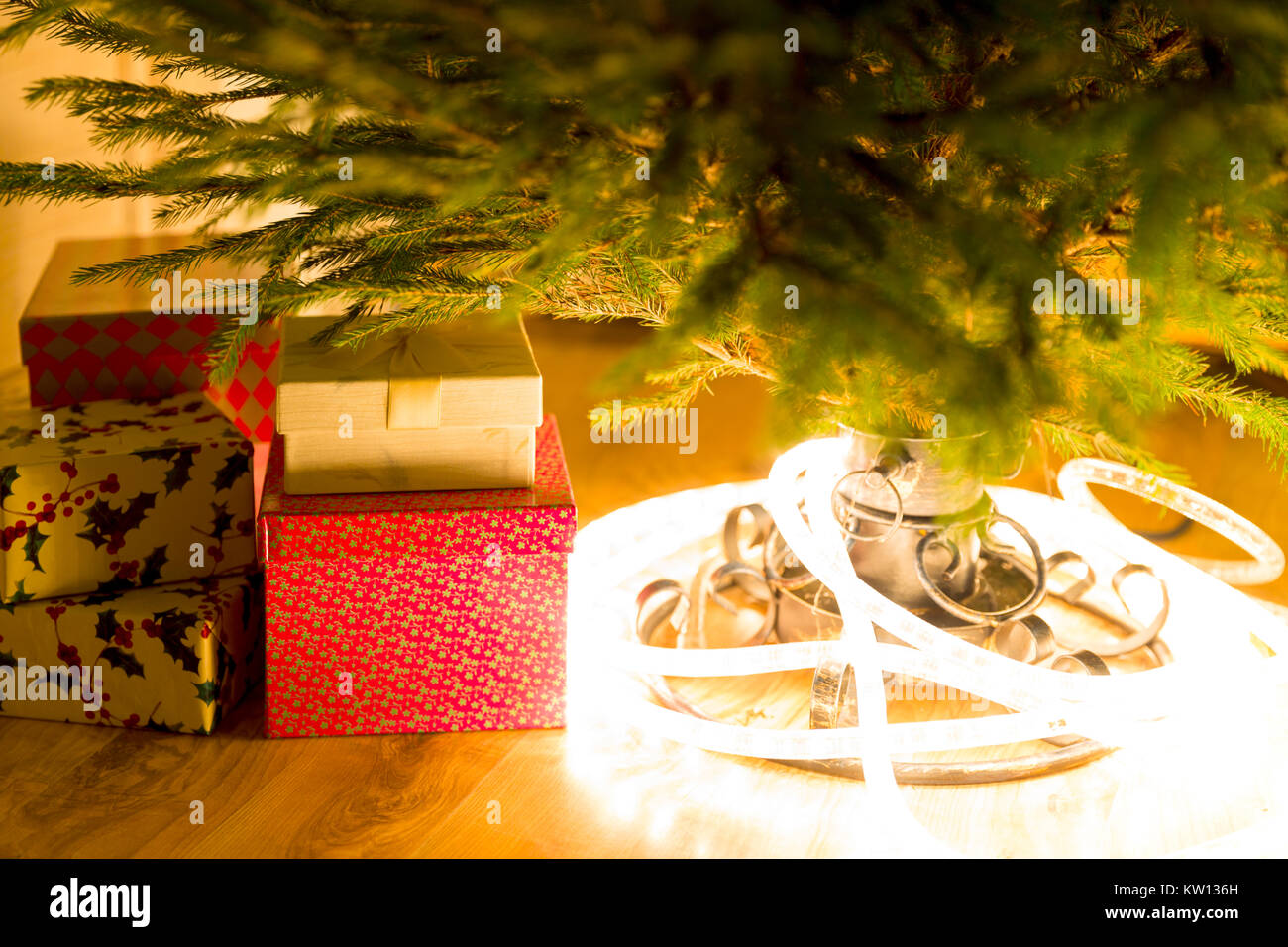 I regali di Natale e le luci sotto il sempreverde albero di natale Foto Stock