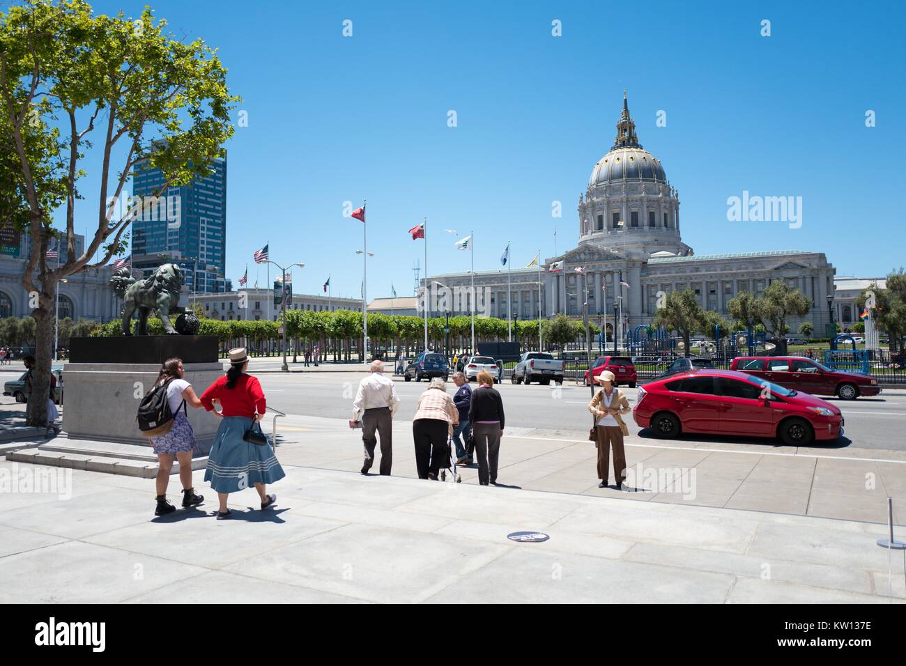 In una giornata di sole nel Centro Civico quartiere di San Francisco, turisti si riuniscono di fronte al municipio; Gay Pride flag è visibile a destra dell'immagine 2016. Foto Stock