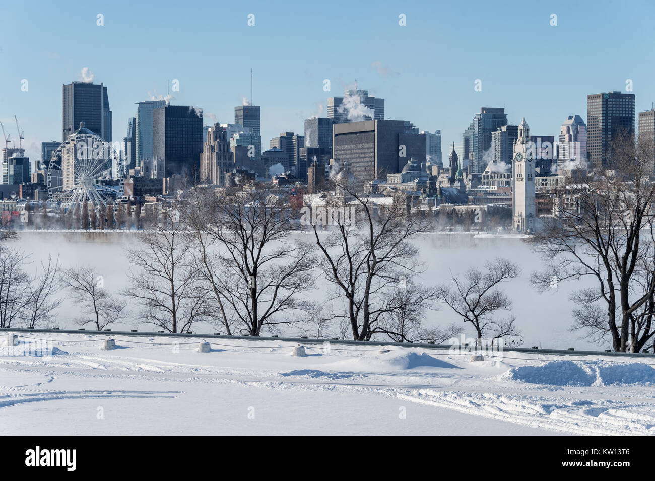 Montreal, CA - 28 dicembre 2017: Lo skyline di Montreal in inverno come ghiaccio nebbia sorge fuori del fiume San Lorenzo Foto Stock