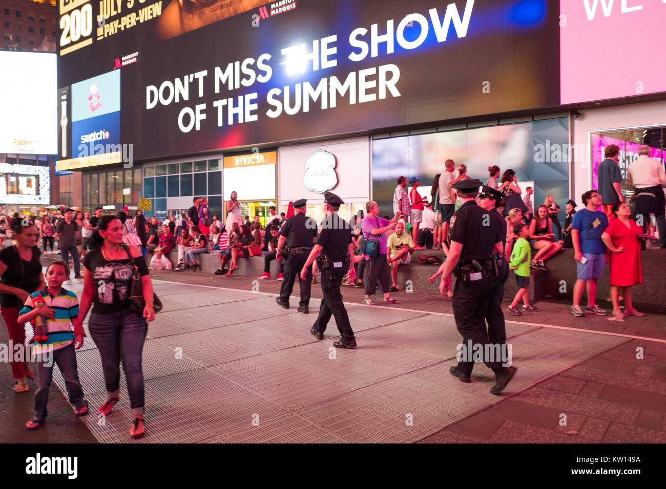 Durante un nero vive questione protestare in New York Times Square a seguito della morte di ripresa di Alton Sterling e Philando Castiglia, una donna che tiene il suo bambino la mano e si affaccia sul apprehensively come una linea di New York City Police Department (NYPD) polizia marzo attraverso il quadrato, 2016. Foto Stock