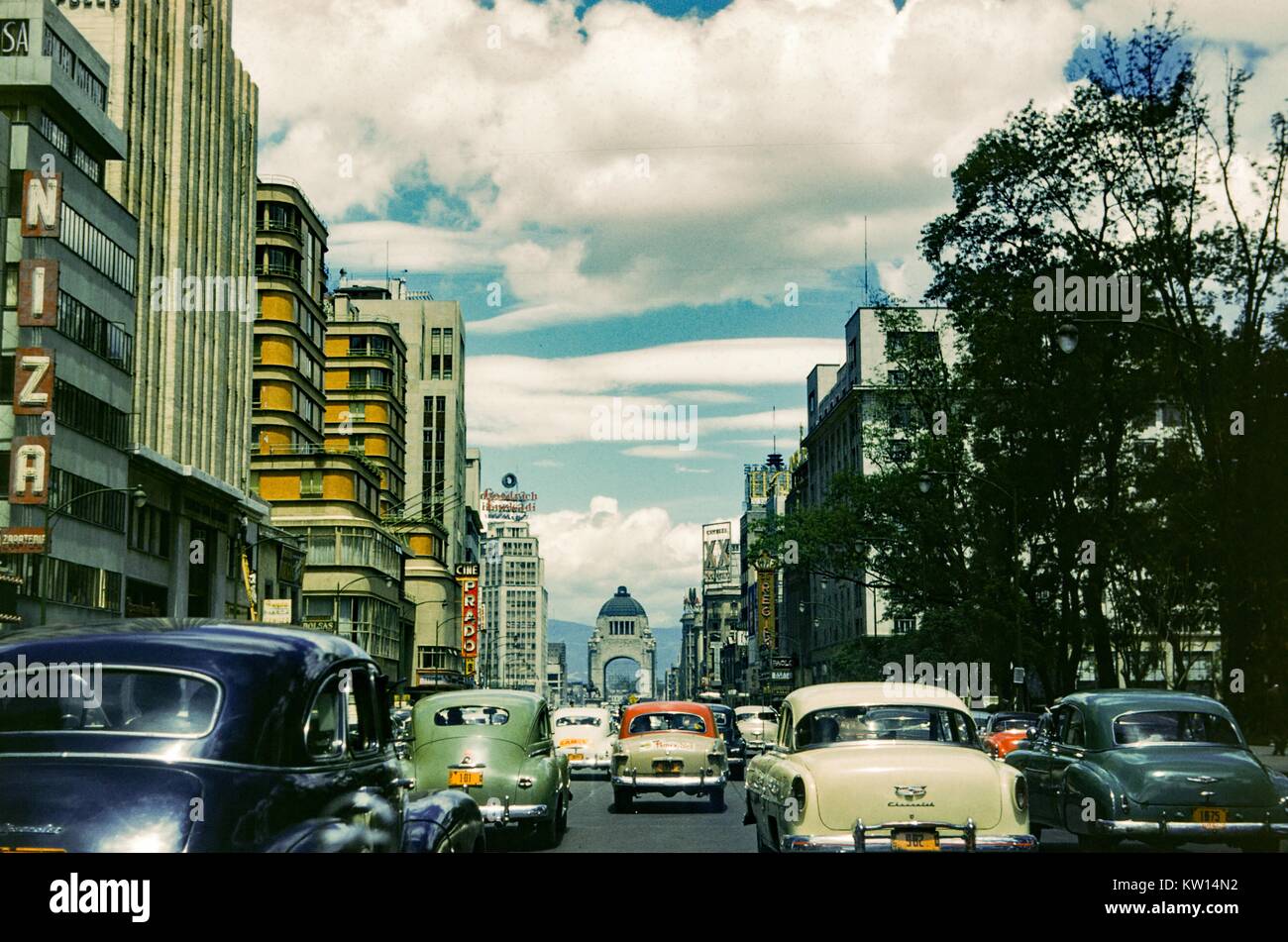 Di automobili che circolano per le strade di Città del Messico con la sequenza Cine Prado, l' Hotel Regis, e molti diversi cartelli pubblicitari visibile, Città del Messico, Messico, 1952. Foto Stock