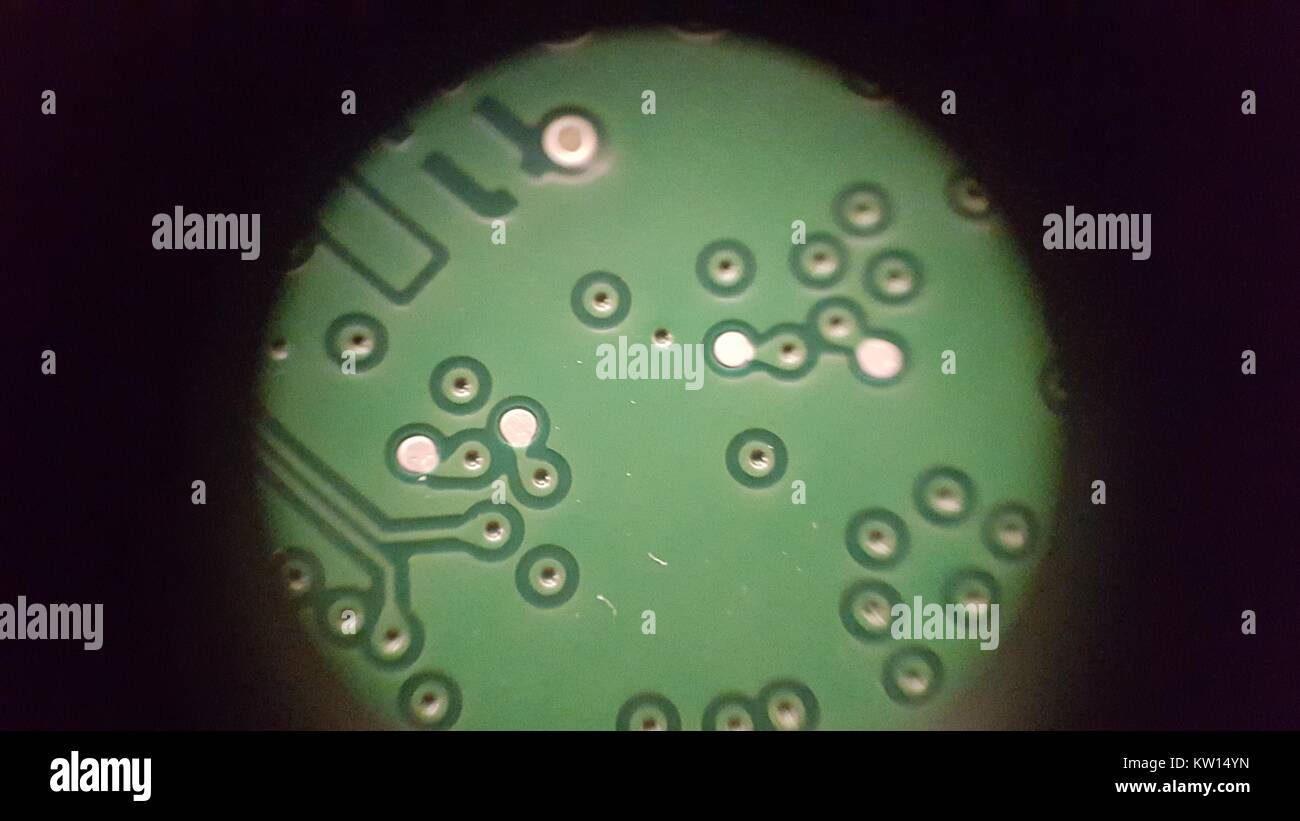 Luce di immagine al microscopio a circa 30x di ingrandimento che mostra le tracce e vias stampigliata sul lato trasversale di una scheda a circuito stampato (PCB), 2016. Foto Stock