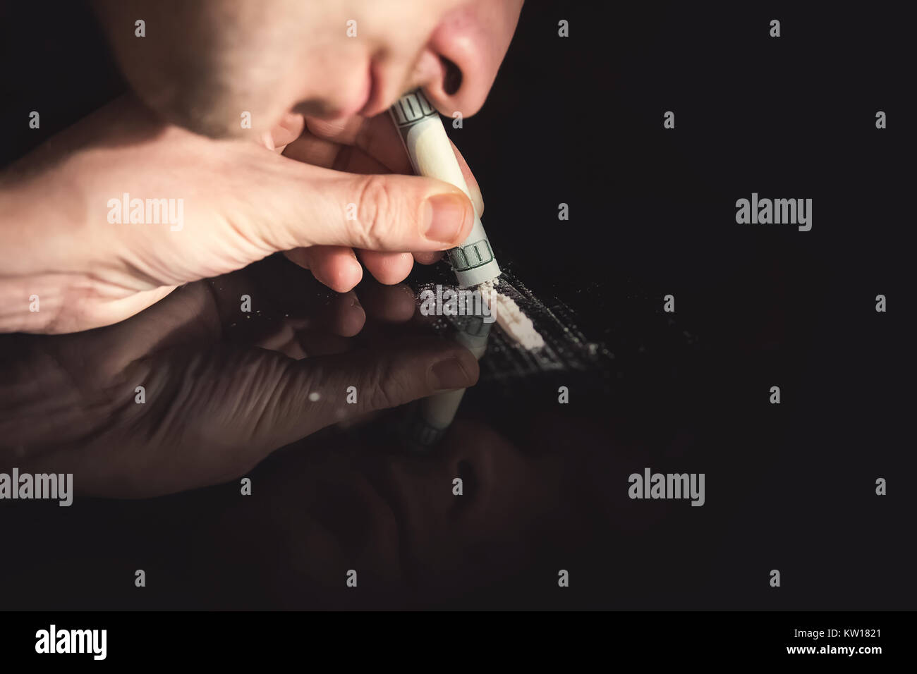 Junkie sbuffare è la cocaina in polvere con la banconota arrotolata. Concetto di stupefacenti. Foto Stock