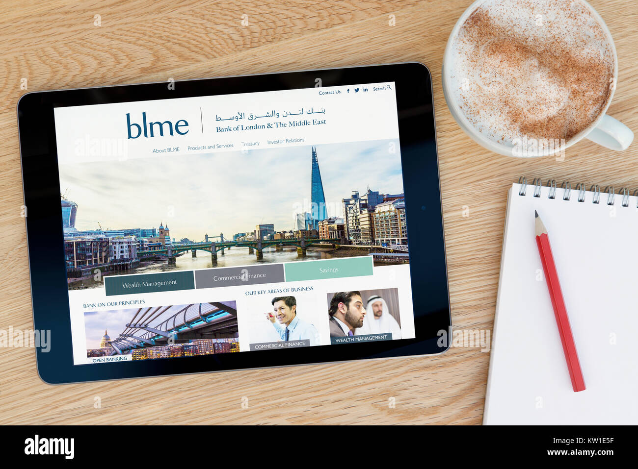 Il BLME (Bank di Londra e il Medio Oriente) sito su un iPad, appoggiato su un tavolo di legno accanto a un blocco note, matita e tazza di caffè (editoriale solo) Foto Stock