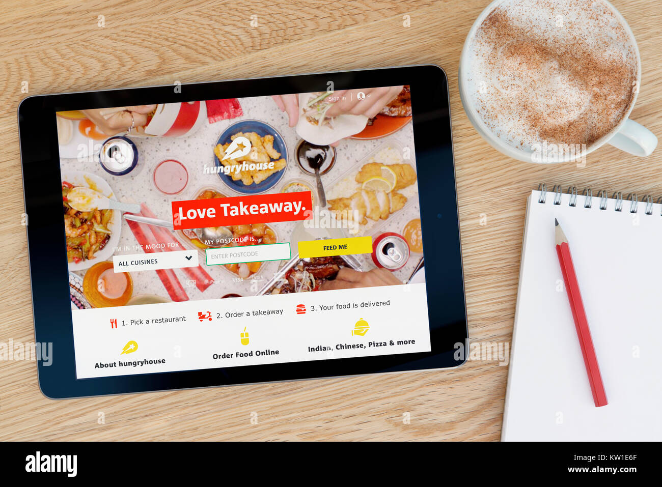 La Fame House sito web su un iPad dispositivo tablet pc che si appoggia su una tavola di legno accanto a un blocco note e matita e una tazza di caffè (editoriale solo) Foto Stock