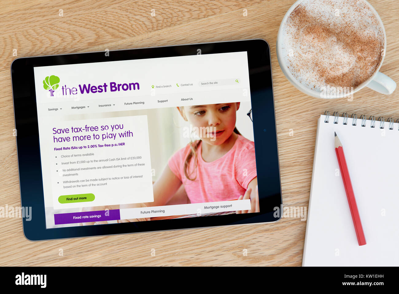 Il West Brom sito su un iPad dispositivo tablet, appoggiato su un tavolo di legno accanto a un blocco note, matita e tazza di caffè (editoriale solo) Foto Stock