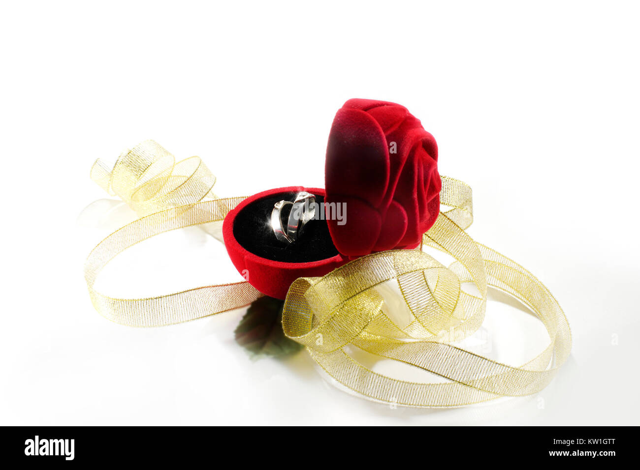Nozze anello di argento in un fiore rosso Scatola decorata con nastro color oro. Foto Stock