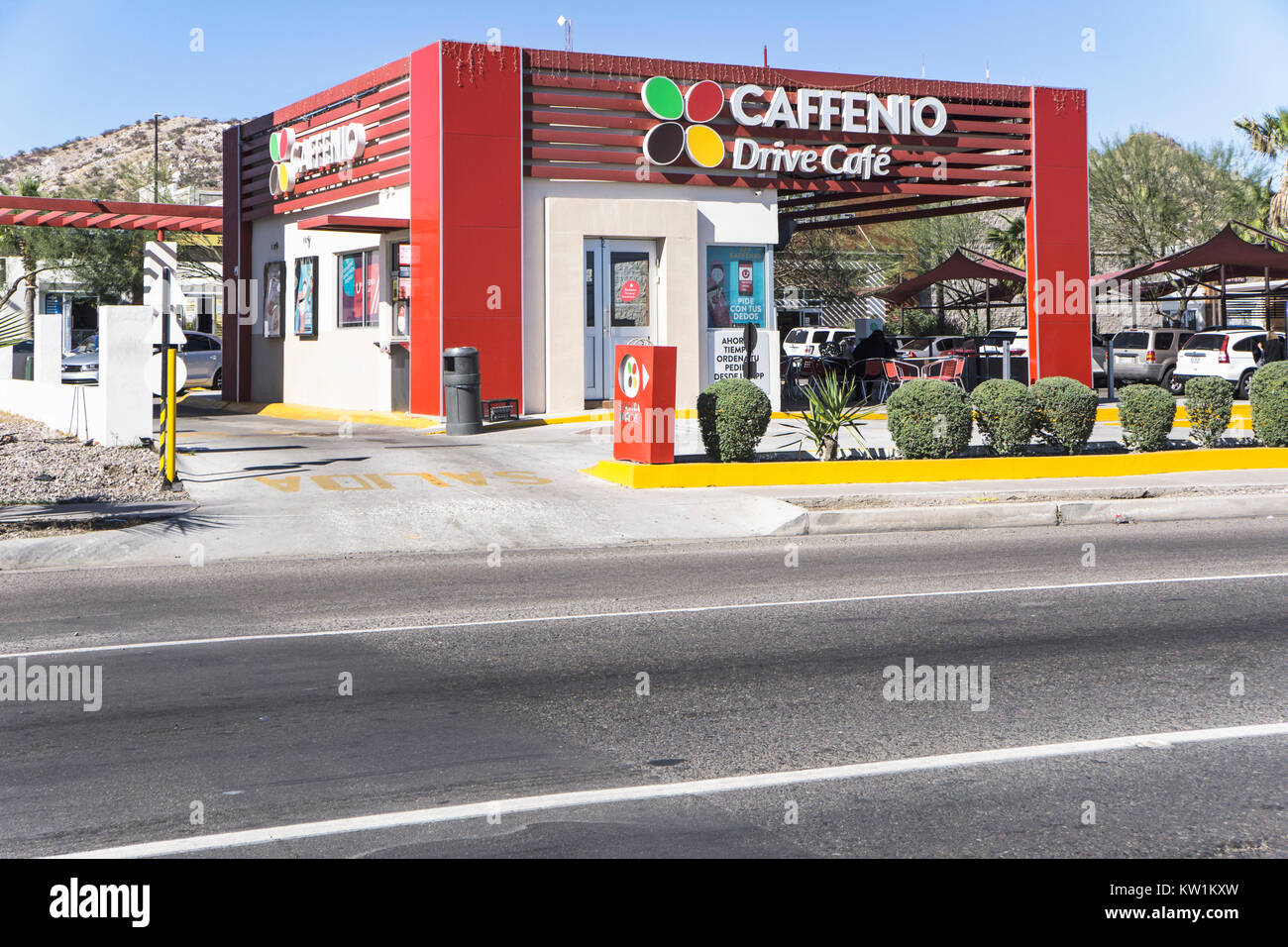 Colorata di rosso e bianco giardini a tema messicano unità stradale attraverso la catena coffee shop con parcheggio e posti a sedere in un patio esterno accanto all'autostrada federale 15 Foto Stock