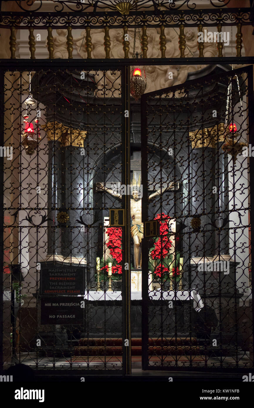 Varsavia, Polonia - 24 dicembre 2017: la figura di Cristo crocifisso dietro cancelli chiusi in San Giovanni Archcathedral nella decorazione di Natale. Mar Morto Foto Stock