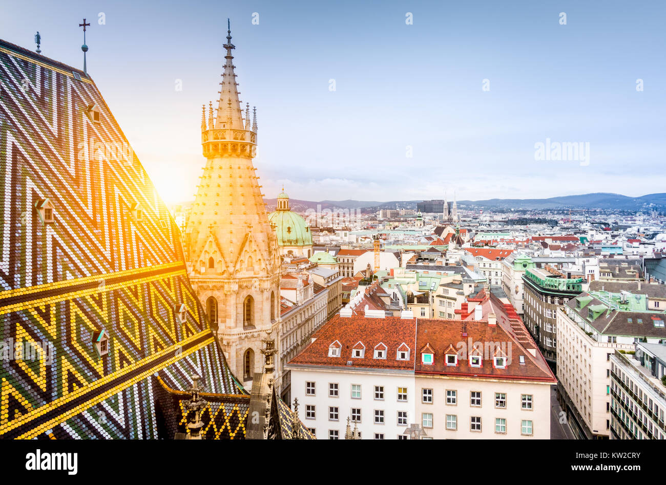 Vista aerea sopra i tetti storici di Vienna dalla torre nord della famosa cattedrale di Santo Stefano in beautiful Golden luce della sera al tramonto Foto Stock