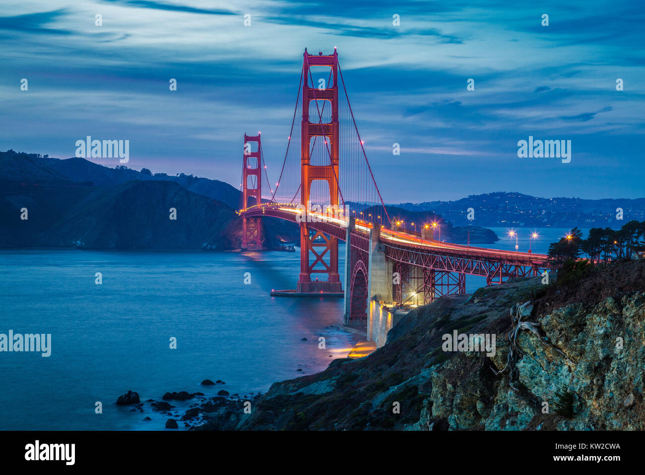 Classic vista panoramica del famoso Golden Gate Bridge visto da scenic Baker Beach in splendida post tramonto tramonto con cielo blu e nuvole al tramonto in Foto Stock