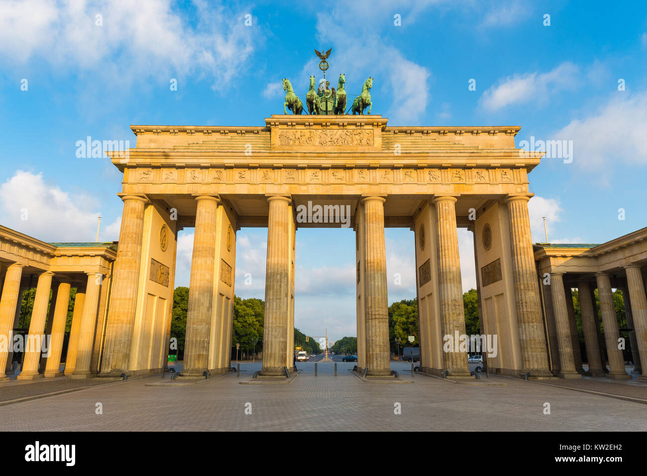 Famoso Brandenburger Tor (Porta di Brandeburgo), uno dei più noti monumenti e simboli nazionali della Germania, in beautiful Golden. La luce del mattino Foto Stock