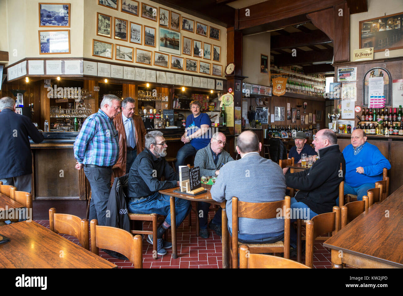 I clienti a guardare gli anziani giocatori di carte le carte da gioco in Café De Presse, pub belga nella città di Geraardsbergen / Grammont, Fiandre Orientali, Belgio Foto Stock