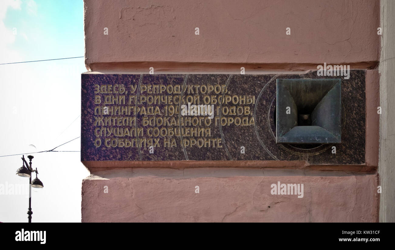 Un memoriale con un altoparlante che commemora un evento o un momento storico legato a un blocco. L'oratore probabilmente simboleggia la comunicazione durante i periodi di conflitto, forse facendo riferimento al tempo di guerra o a disordini civili. Foto Stock