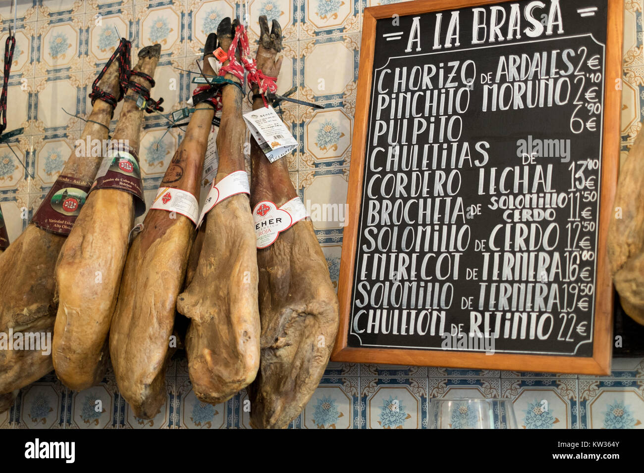 Tapas bar prosciutti e Menu Grill hangin in bar popolare in Málaga, Spagna Foto Stock