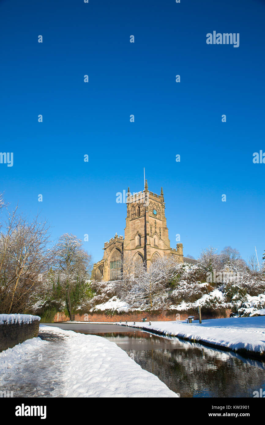 La Chiesa di Santa Maria, kidderminster worcs,. Luminosa mattina di sole, neve sul terreno, canal in primo piano e sorprendente, blu cielo sopra. Formato verticale. Foto Stock