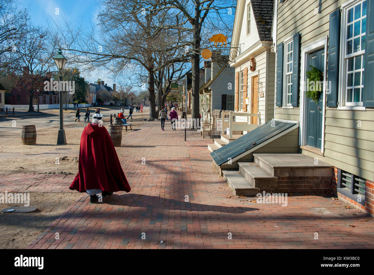 Stati Uniti Virginia VA Colonial Williamsburg duca di Gloucester Street un epoca coloniale casa a Natale con ghirlande donna con red cape Foto Stock