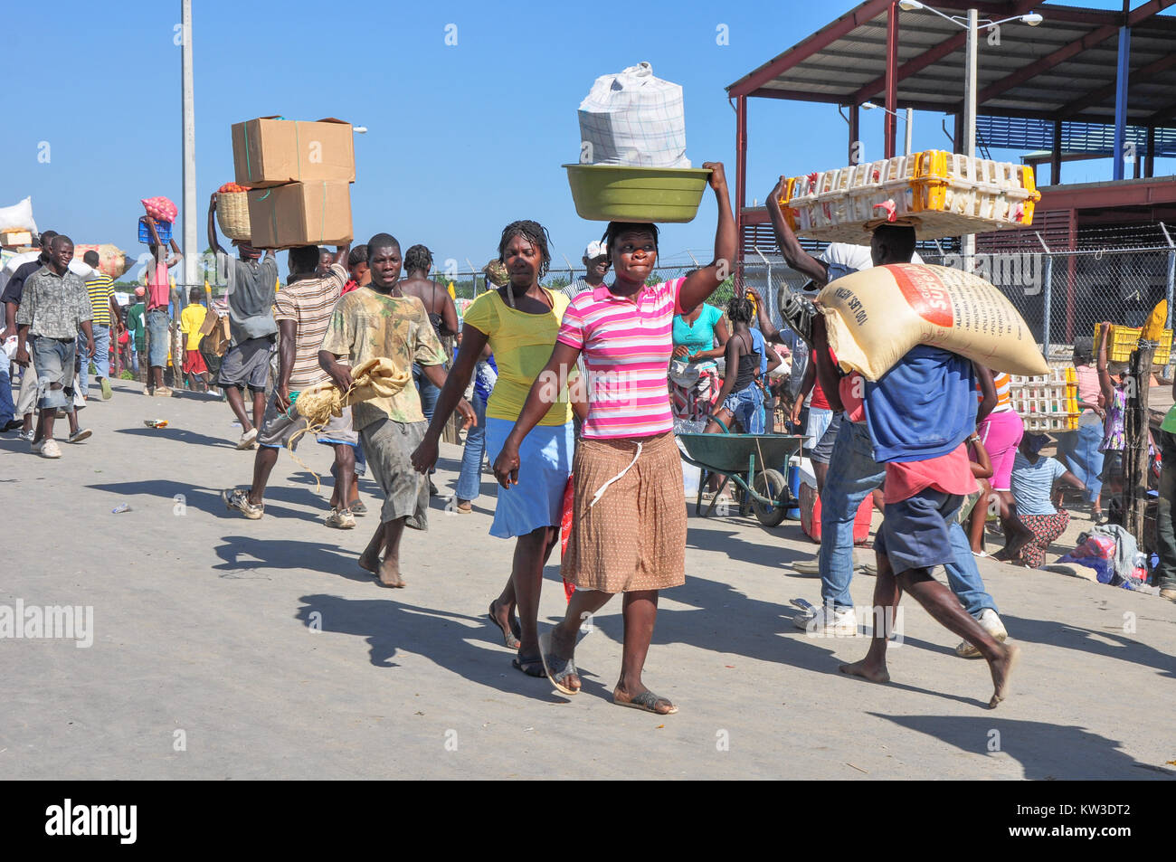 Gli haitiani che trasportano merci sulla loro testa come si incrociano Ounaminthe, Haiti e Dajabon, Repubblica Dominicana confine. Foto Stock