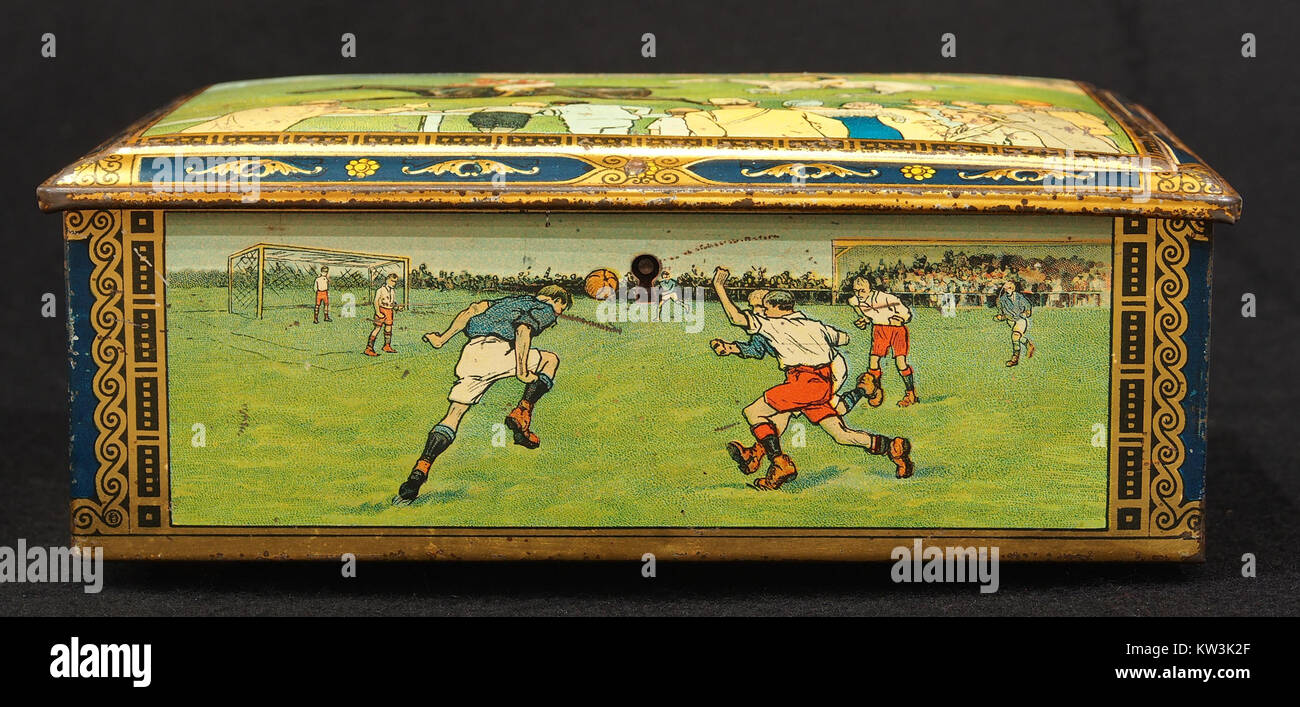 Questa scatola di biscotti vintage del 1930 circa presenta illustrazioni di vecchi sport. Lo stagno riflette la cultura sportiva popolare del tempo e funge da oggetto da collezione, offrendo uno sguardo al passato. Foto Stock
