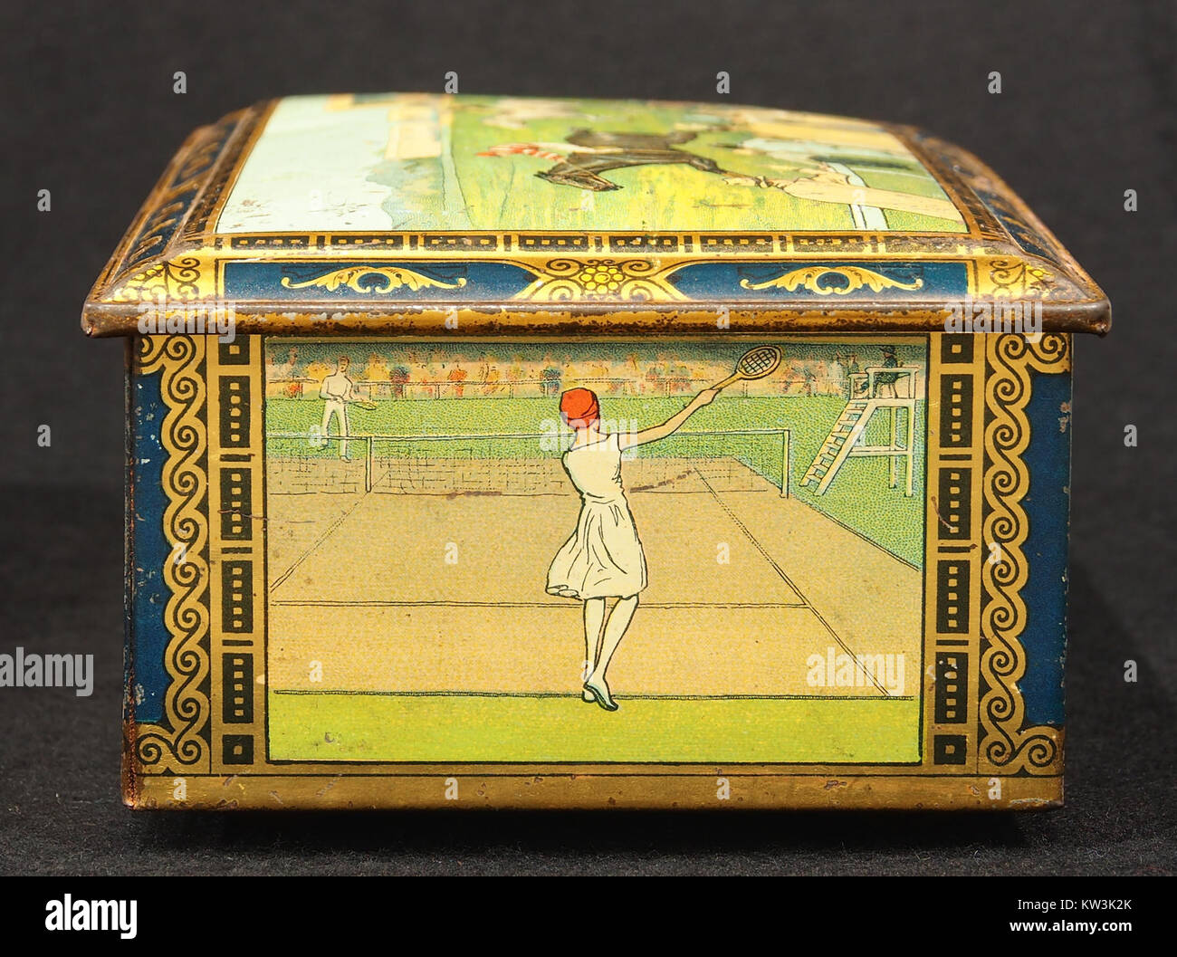 Questo *biscotto in stagno* del 1930 circa presenta illustrazioni di vecchi sport, catturando lo spirito delle attività ricreative dei primi anni del XX secolo. Lo stagno probabilmente serviva sia come elemento funzionale che decorativo, mostrando gli sport popolari del tempo e riflettendo le tendenze culturali dell'epoca. Foto Stock