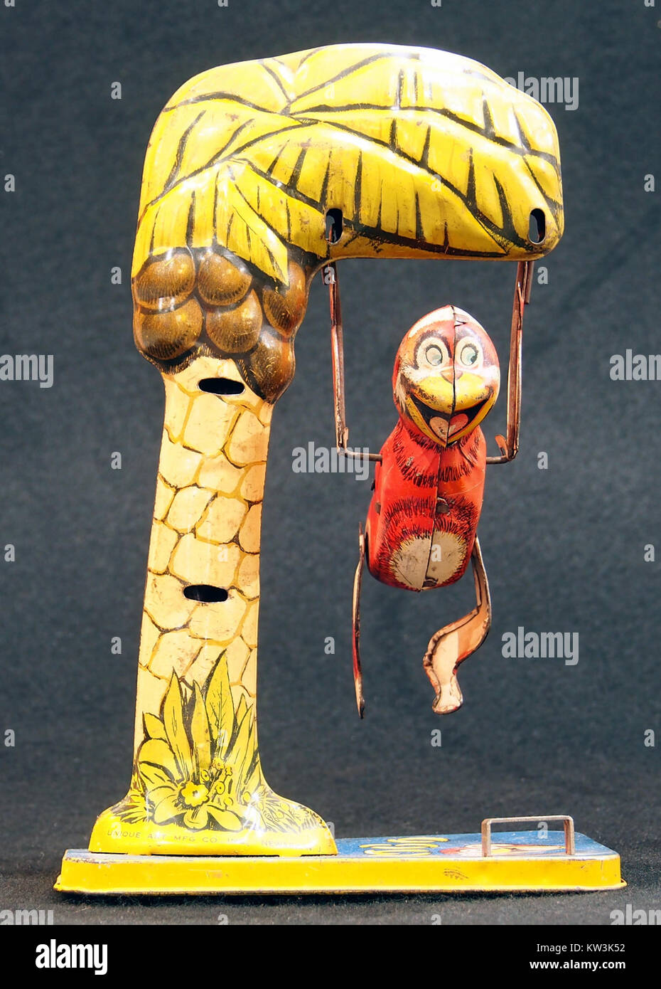 Questa immagine mostra Bombo, una scimmia giocattolo di latta, arroccata in un albero. Il giocattolo è una rappresentazione nostalgica dei giocattoli meccanici dell'inizio del XX secolo, noti per la loro natura giocosa e interattiva. Foto Stock