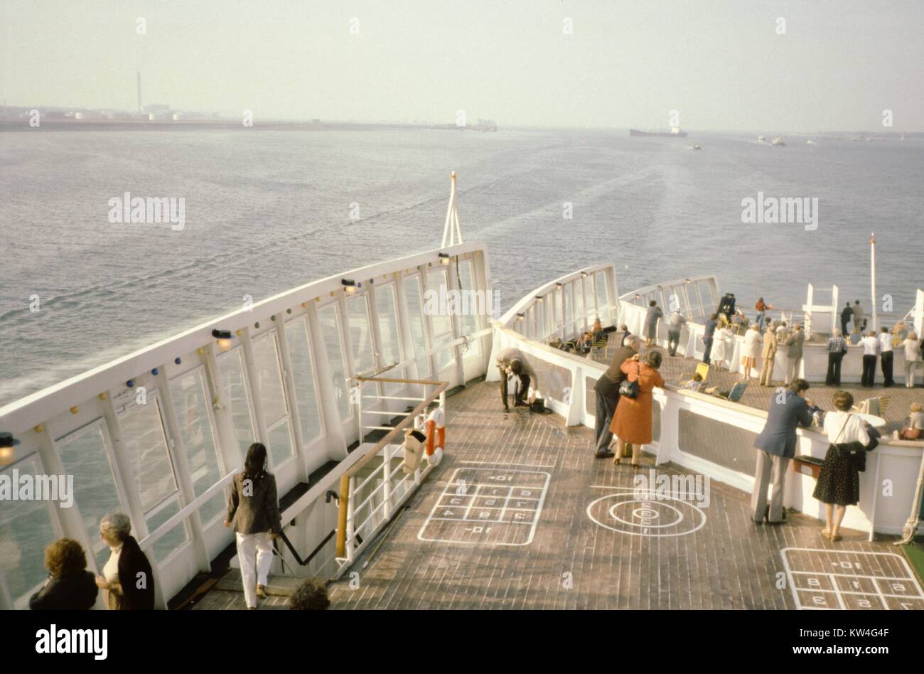 I viaggiatori si riuniscono sul ponte di poppa della Cunard Line la Queen Elizabeth 2 nave da crociera, dove i corsi per varie partite sono state dipinte, in mare, 1975. Foto Stock