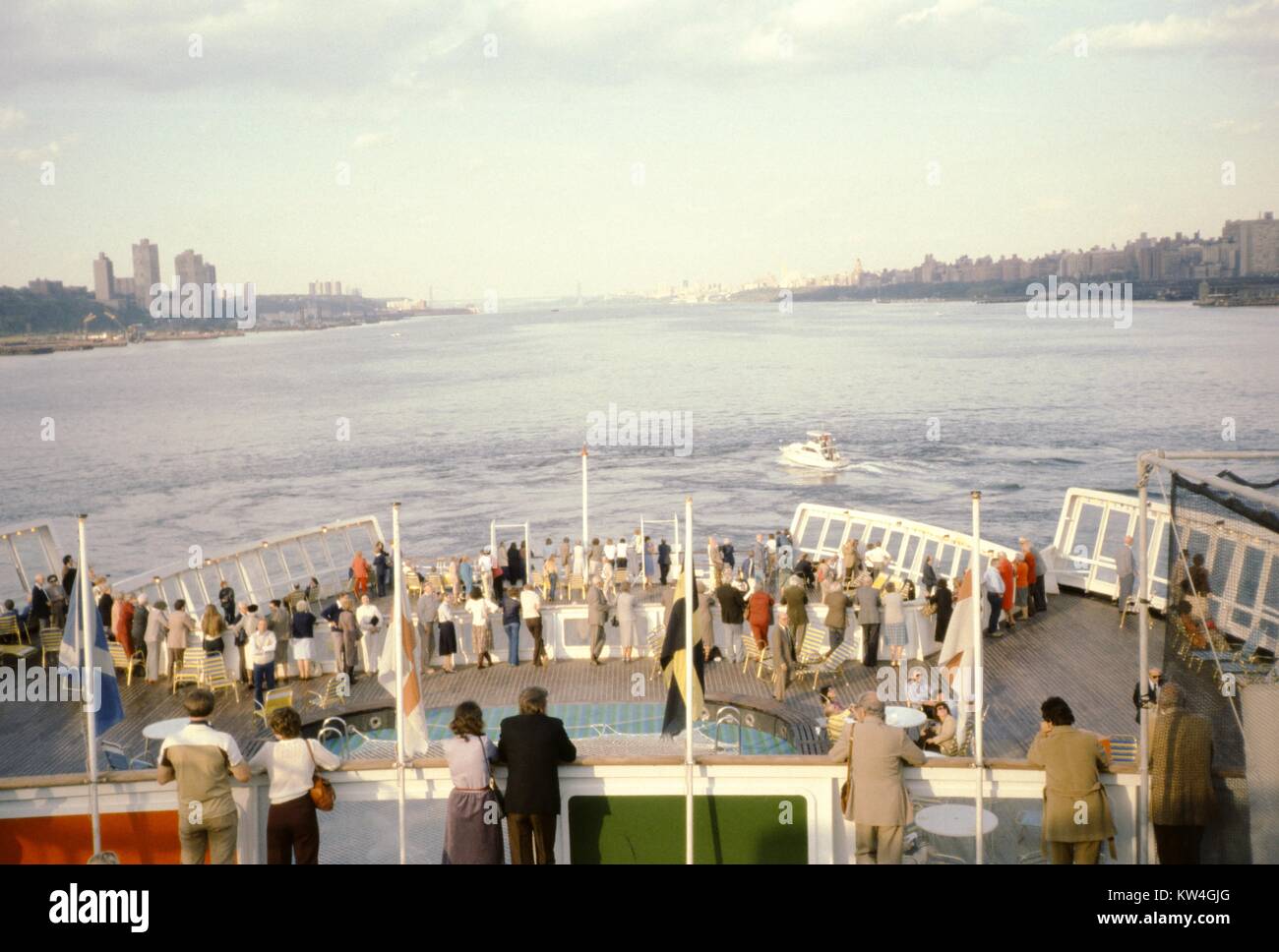 Passeggeri rilassarsi sul ponte di poppa della Cunard Line la Queen Elizabeth 2 la nave di crociera mentre lascia il porto di New York, New York, 1975. Foto Stock