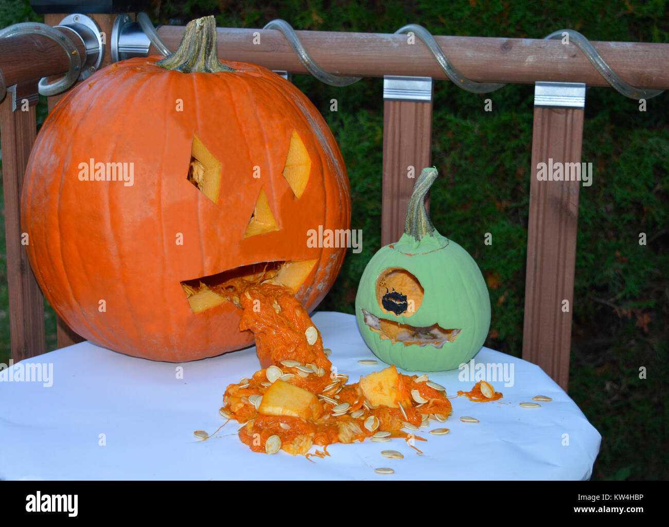 Un paio di divertenti zucca di Halloween di amici seduti su un tavolo in attesa di tenebre per spaventare il trucco o treaters. Foto Stock