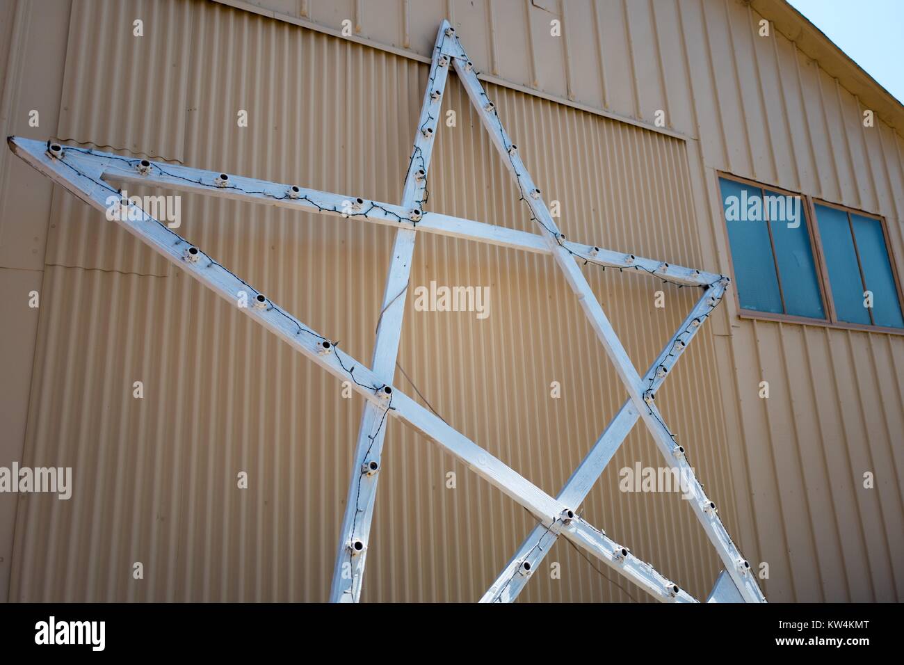 Iconico cinque-punto stella illuminata da appendiabiti si appoggia contro il sito di Moffett Field museo storico all'interno dell'area protetta della NASA Ames Research Center campus in Silicon Valley Town di Palo Alto, California, 25 agosto 2016. Hangar uno, che è tra le più grandi del mondo free-standing strutture, stata affittata a Google Inc planetario di affiliazione Ventures nel 2016 (insieme a Moffett Field) per 60 anni a un costo di 1,6 miliardi di dollari, contingenti alla ristrutturazione della società la struttura, California. Foto Stock