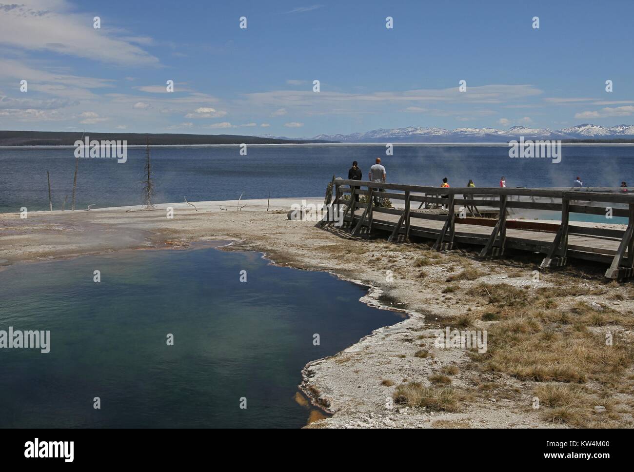 I turisti in piedi su una passerella in corrispondenza del bordo dell'Abisso piscina presso il West Thumb Geyser Basin, il Parco Nazionale di Yellowstone, Wyoming Maggio, 2013. Immagine cortesia Jim Peaco/Parco Nazionale di Yellowstone. Foto Stock