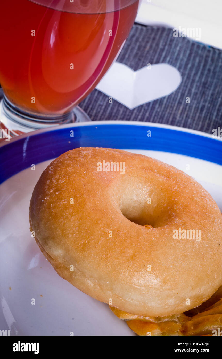 Ciambella calda per la cottura a vapore e il colore oro pronti per la vostra prima colazione o il vostro snack con un bicchiere di succo di arancia Foto Stock