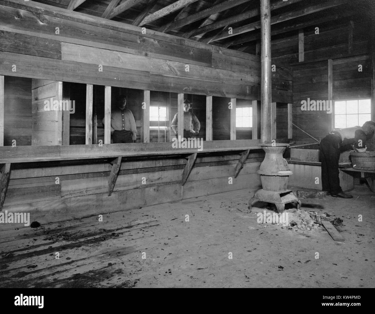 Acquedotto a supporto dei lavoratori all'interno di un edificio di camp che contiene una legno-sparò stufa durante la costruzione del Catskill acquedotto, New York, Stati Uniti, gennaio 20, 1910. Dalla Biblioteca Pubblica di New York. Foto Stock