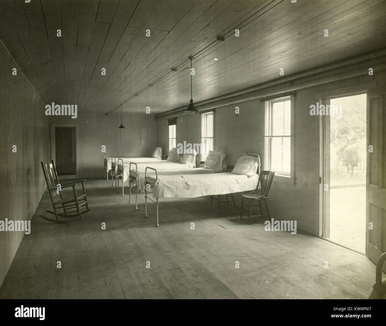 Cinque letti coperti di biancheria bianca le pareti dell'infermeria di un acquedotto lavoratori camp durante la costruzione di un acquedotto di Catskill, New York, Stati Uniti, 21 giugno 1910. Dalla Biblioteca Pubblica di New York. Foto Stock