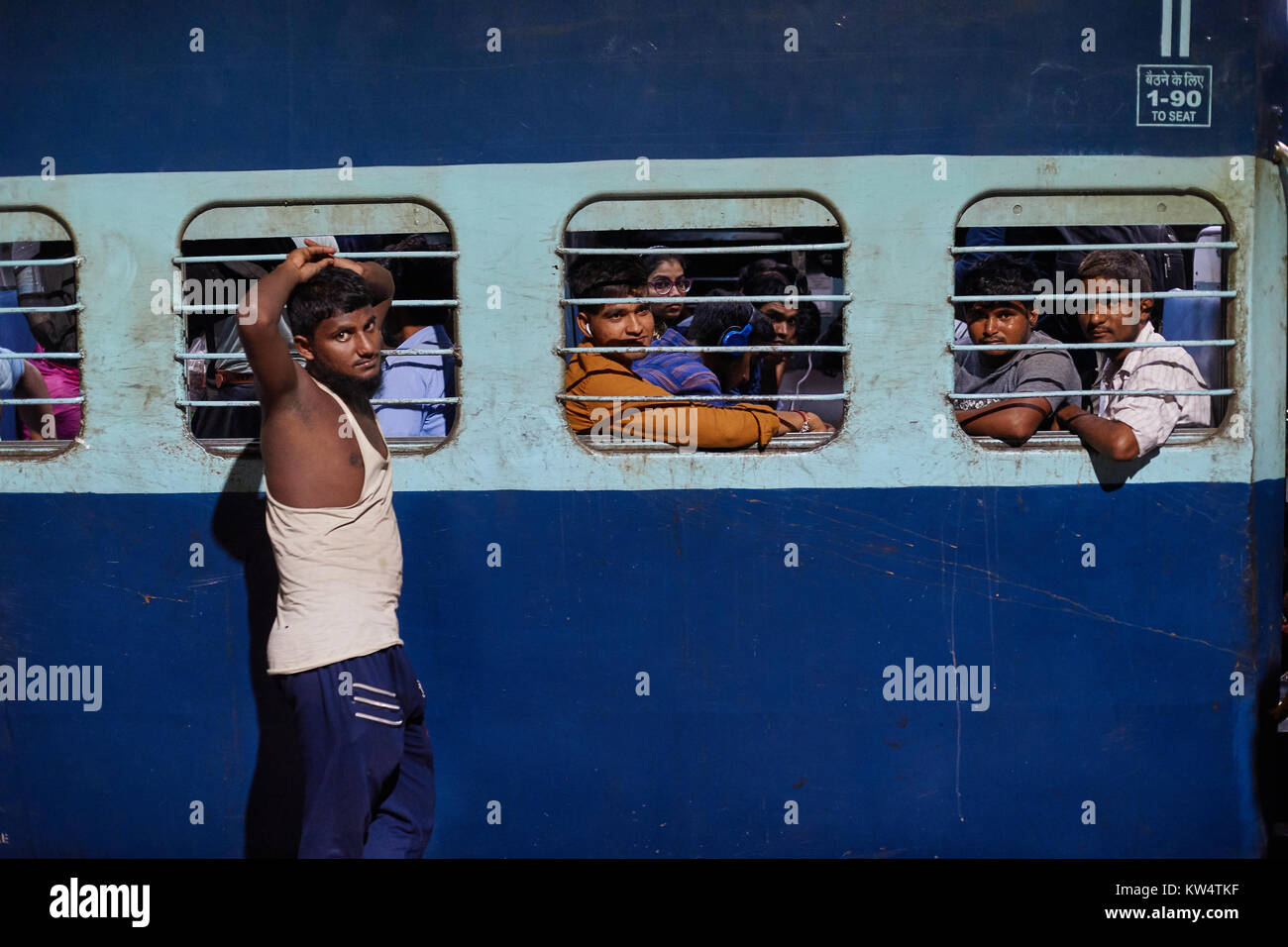 Indian gli uomini a un treno windows, Hazrat Nizamuddin stazione ferroviaria, Delhi, India Foto Stock