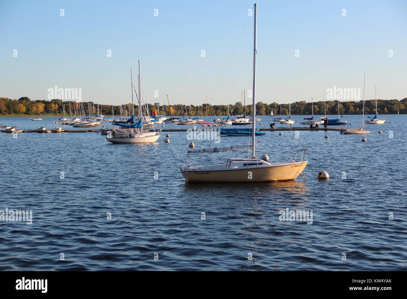 Barche sul lago Calhoun, situato a Minneapolis, Minnesota, nell'ottobre 2017. La scena cattura una vista serena del lago con le barche sull'acqua circondate dal fogliame autunnale. Foto Stock