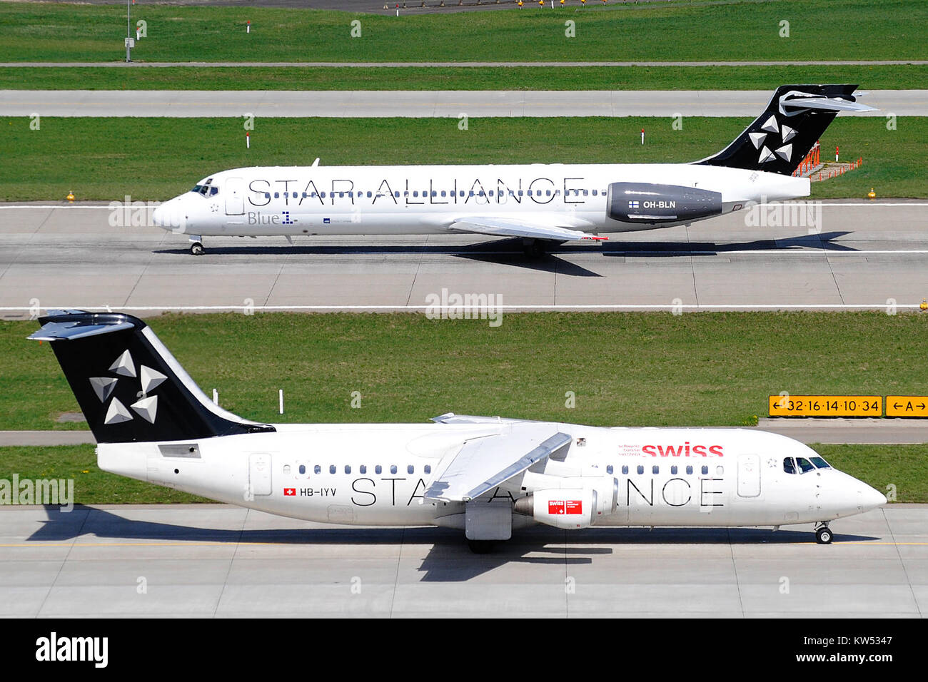 L'immagine cattura un Boeing 717 Blue1 (OH-BLN) e un Avro RJ100 svizzero (HB-IYV) all'aeroporto di Zurigo (LSZH) nel 2011. Questi aeromobili facevano parte delle flotte delle rispettive compagnie aeree, riflettendo la storia dell’aviazione e l’industria degli aeromobili commerciali durante quel periodo. Foto Stock