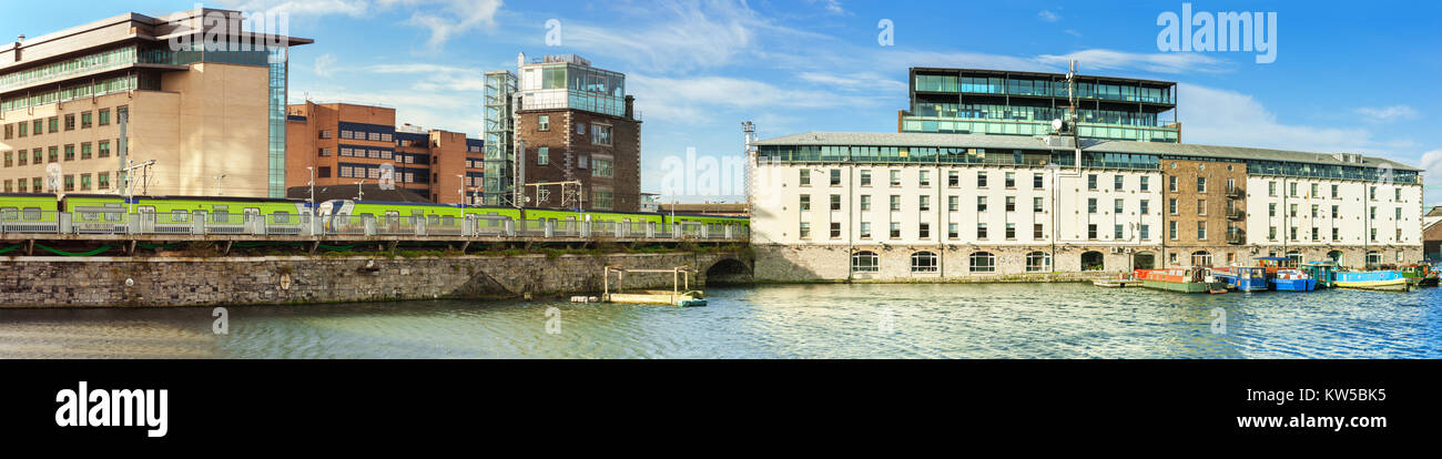 Pezzo rinnovato di Dublin Docklands o banchine di silicio su un mattino luminoso con longboats mooded nell'allegato del Grand Canal. Immagine panoramica. Foto Stock