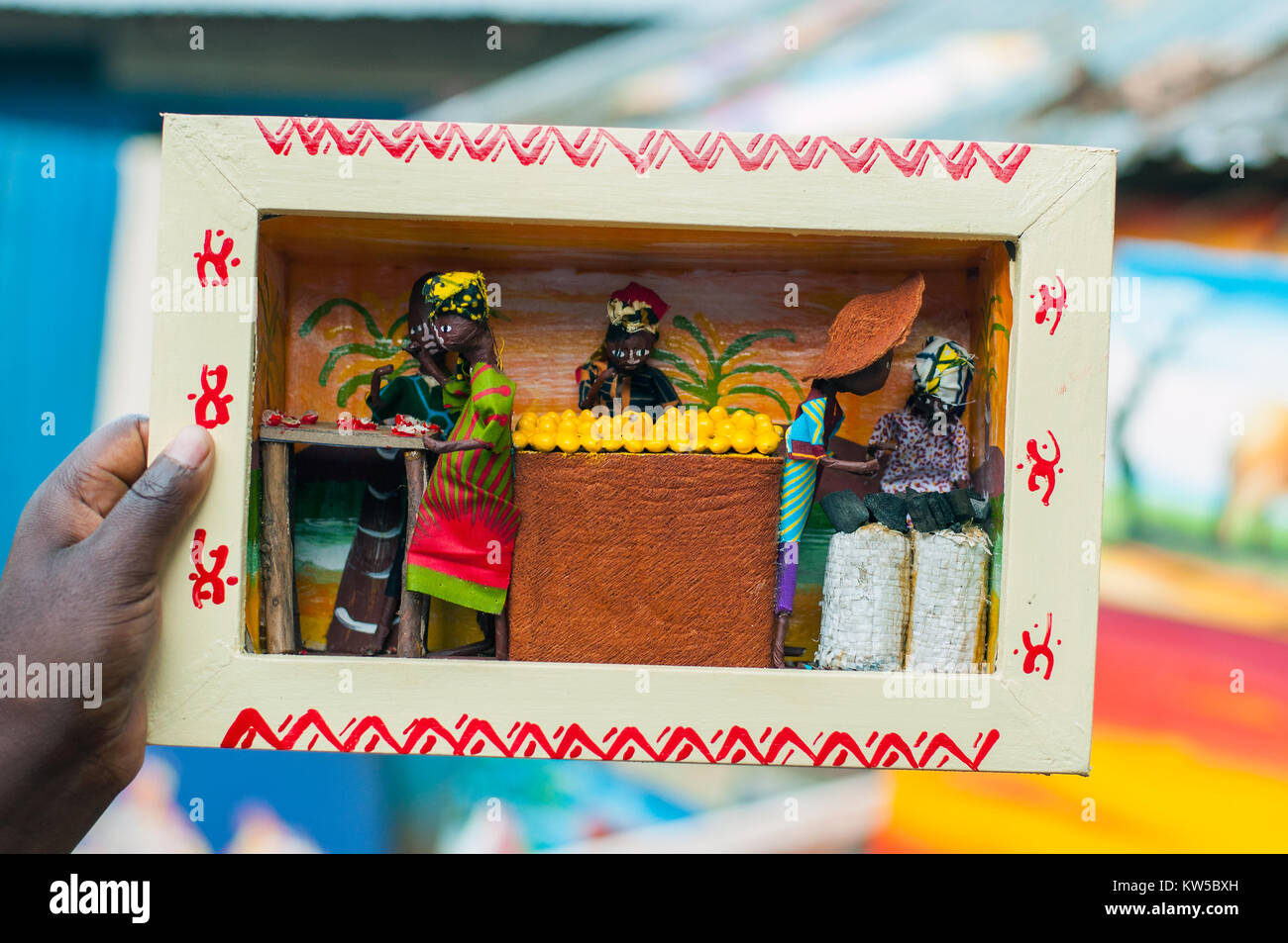Titolare di stallo tenendo in box modello di stallo di frutta, centro artigianale, Entebbe, Wakiso, Uganda Foto Stock
