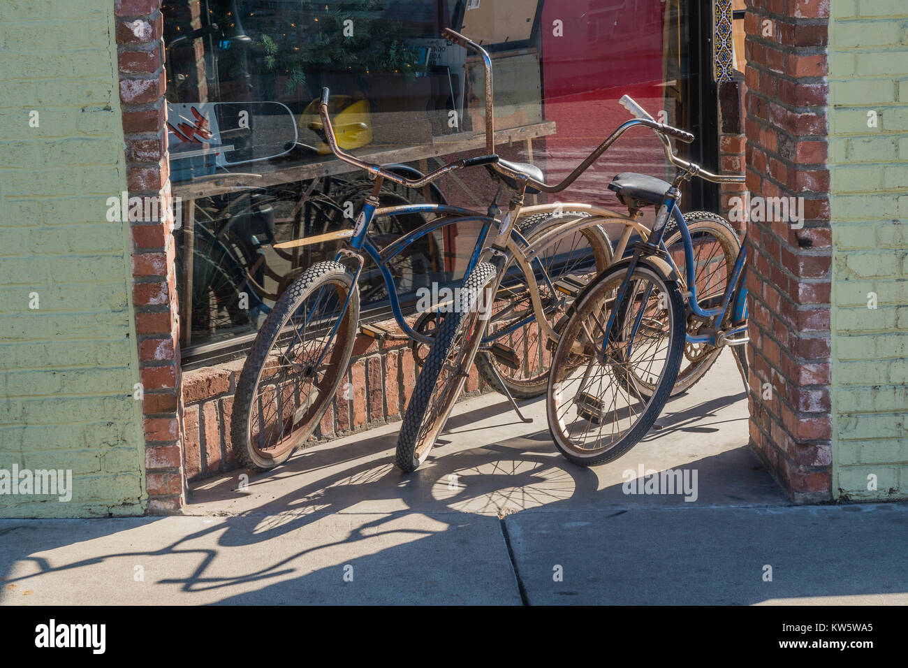 Tre beach cruiser biciclette parcheggiate fuori un negozio di fronte a Pismo Beach, California. Foto Stock