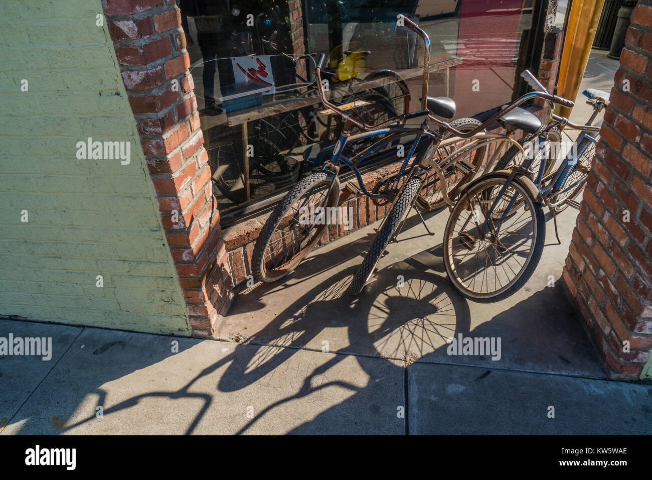 Tre beach cruiser biciclette parcheggiate fuori un negozio di fronte a Pismo Beach, California. Foto Stock