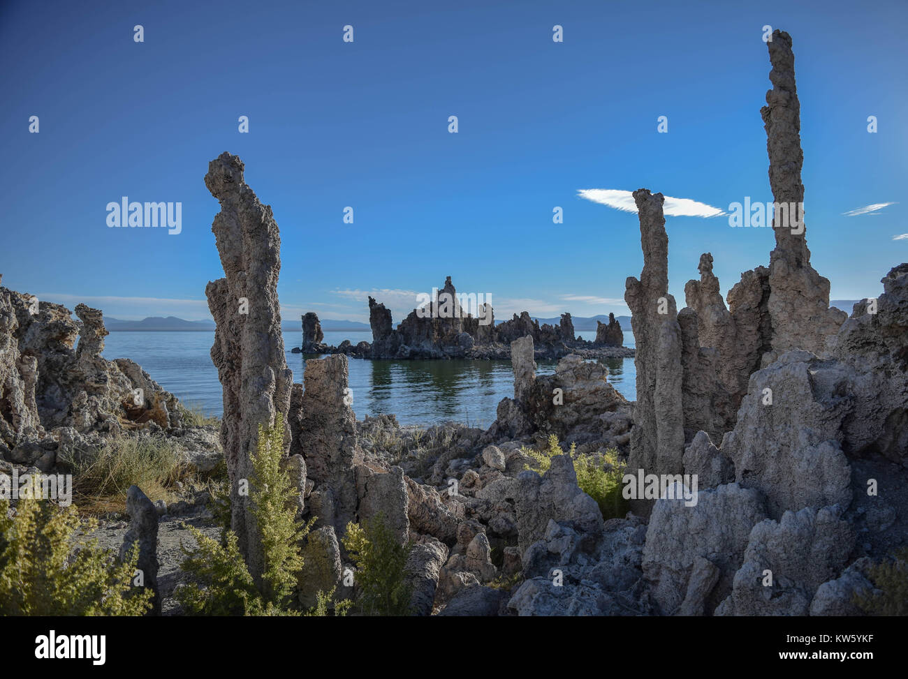 Più tufas, Mono lago, un cielo blu chiaro con una interessante cloud, e le montagne lontane, Mono Lago di tufo Riserva Naturale Statale, in California Foto Stock