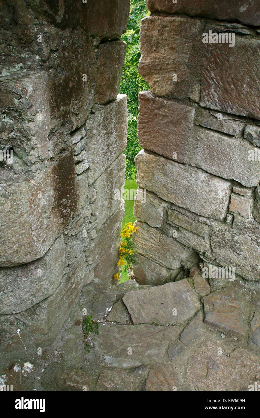 Schießscharte einer alten Burg, in einer Mauer aus Stein Foto Stock