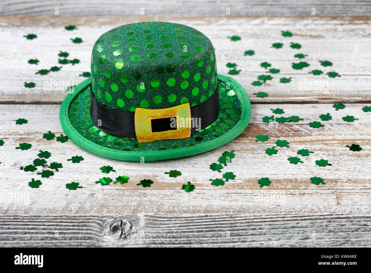 San Patrizio giorno buona fortuna hat con trifogli lucido su bianco rustico di tavole di legno in vista ravvicinata Foto Stock