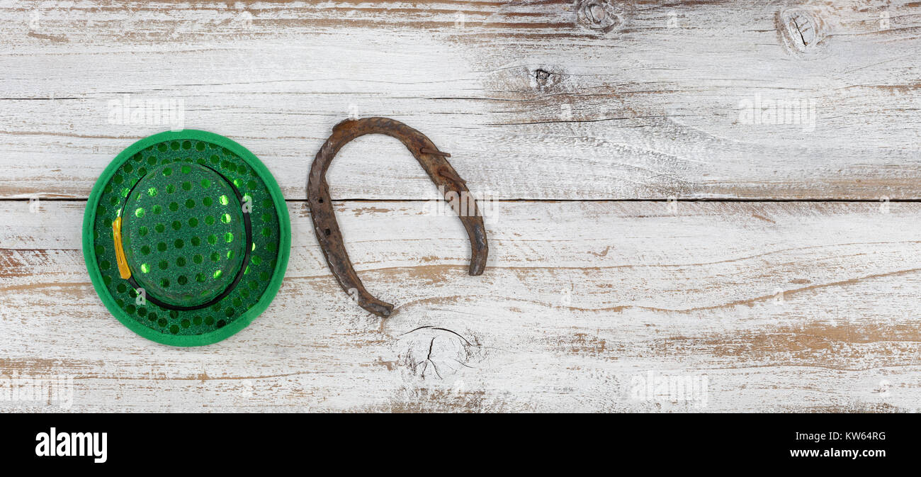 Il giorno di San Patrizio buona fortuna hat e ferri di cavallo su spiovente di legno bianco in vista aerea Foto Stock